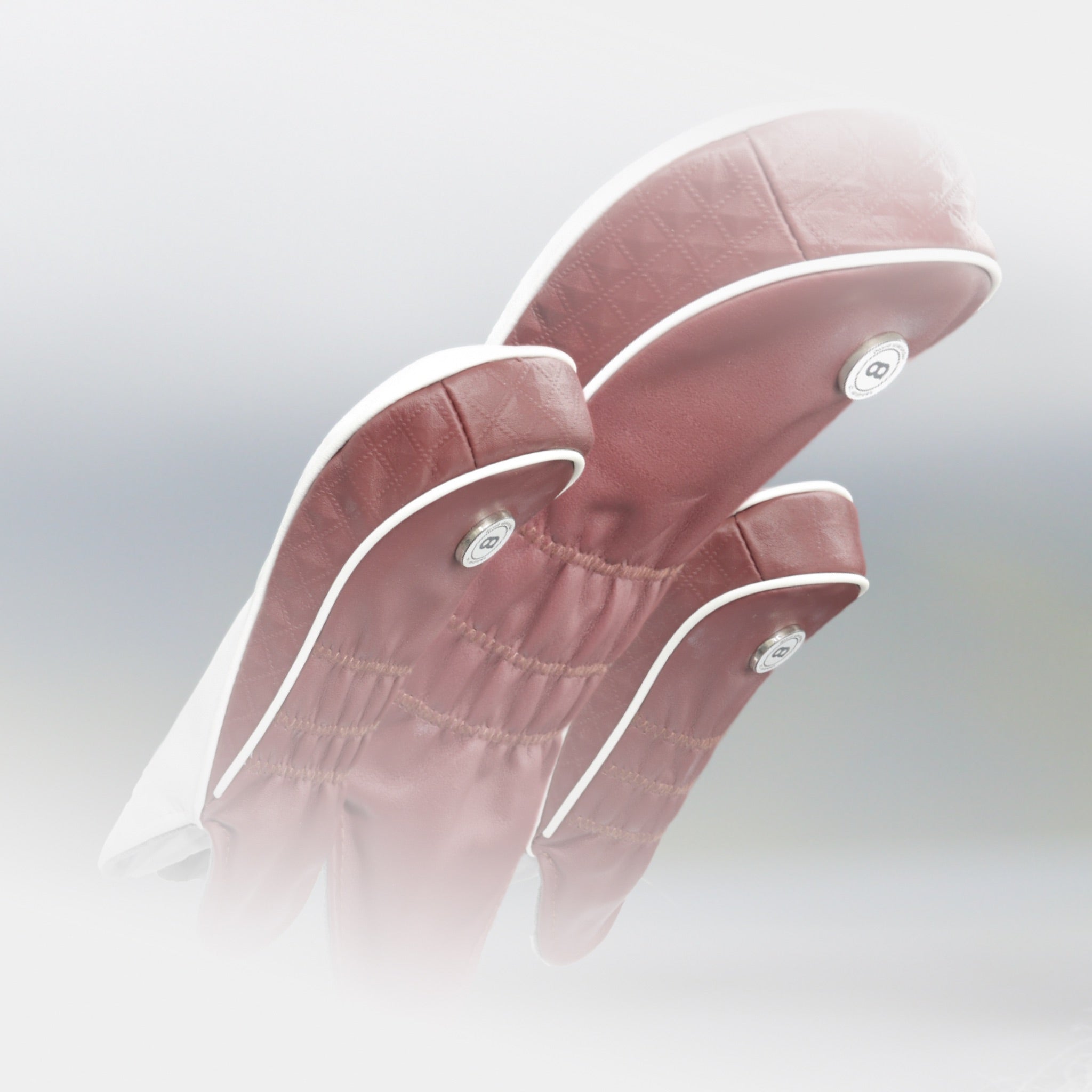A set of burgundy leather golf club headcovers by Dave Alexander