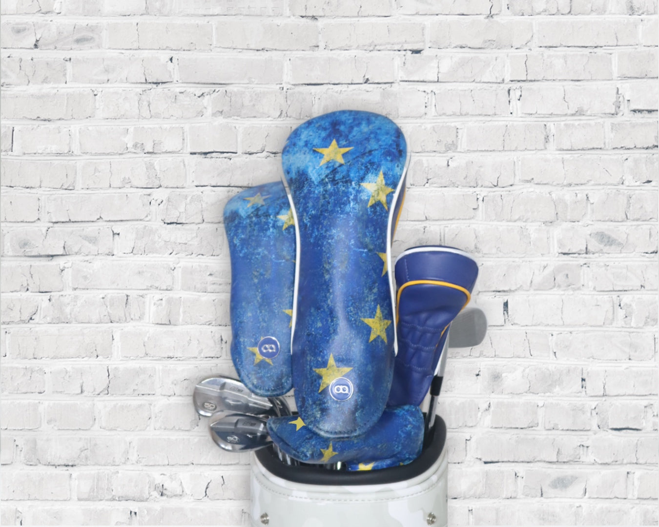 Blue and yellow Team Europe leather golf club headcover set by David Alexander against a white wall background.