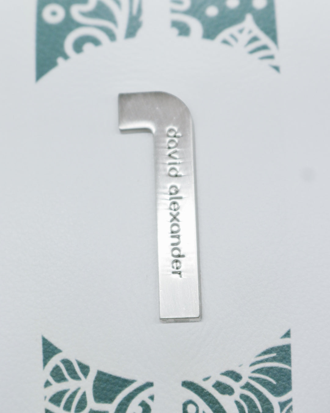 Chrome insignia on white and teal green leather headcover by David Alexander