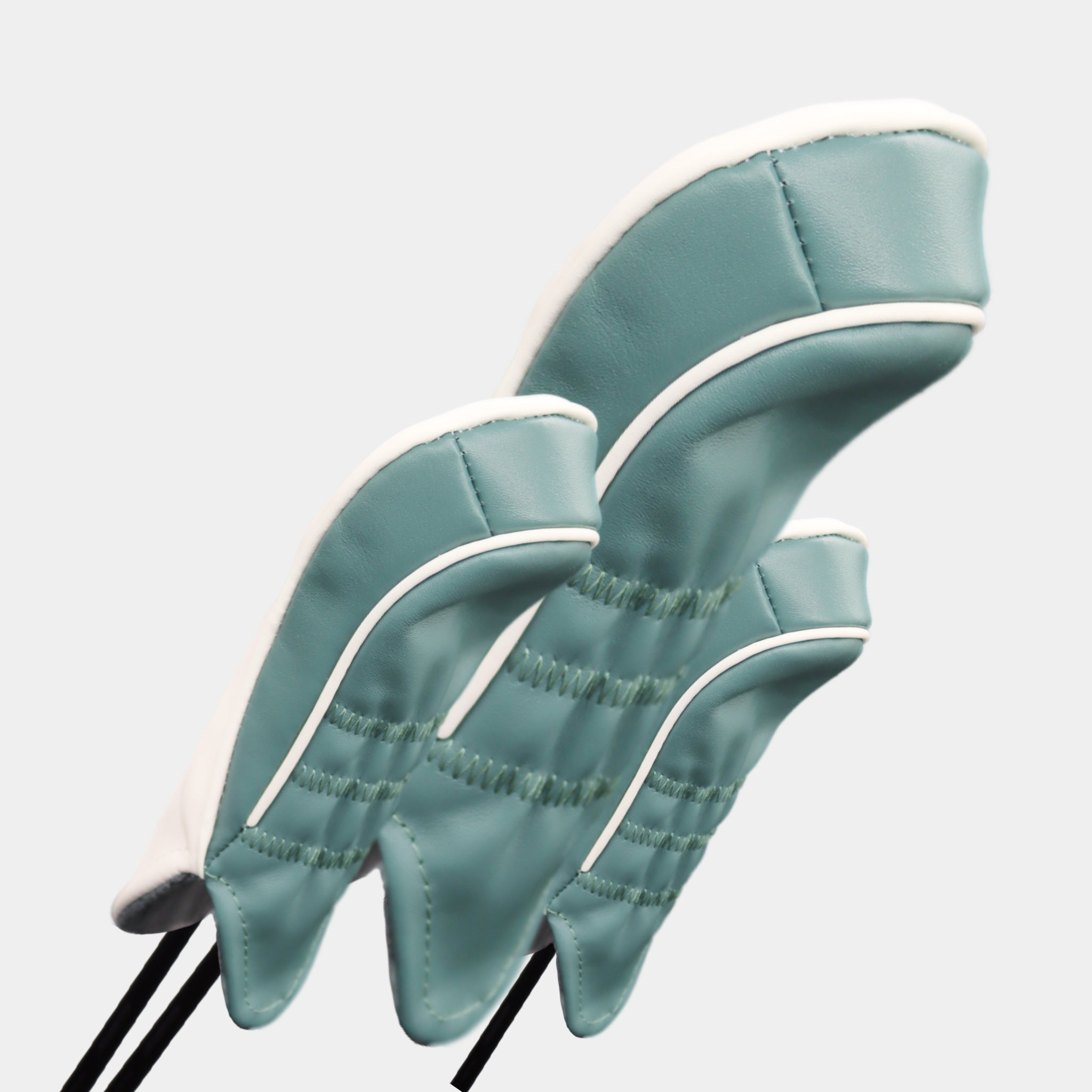 A set of green and white leather golf club headcovers with a henna stripe design by David Alexander