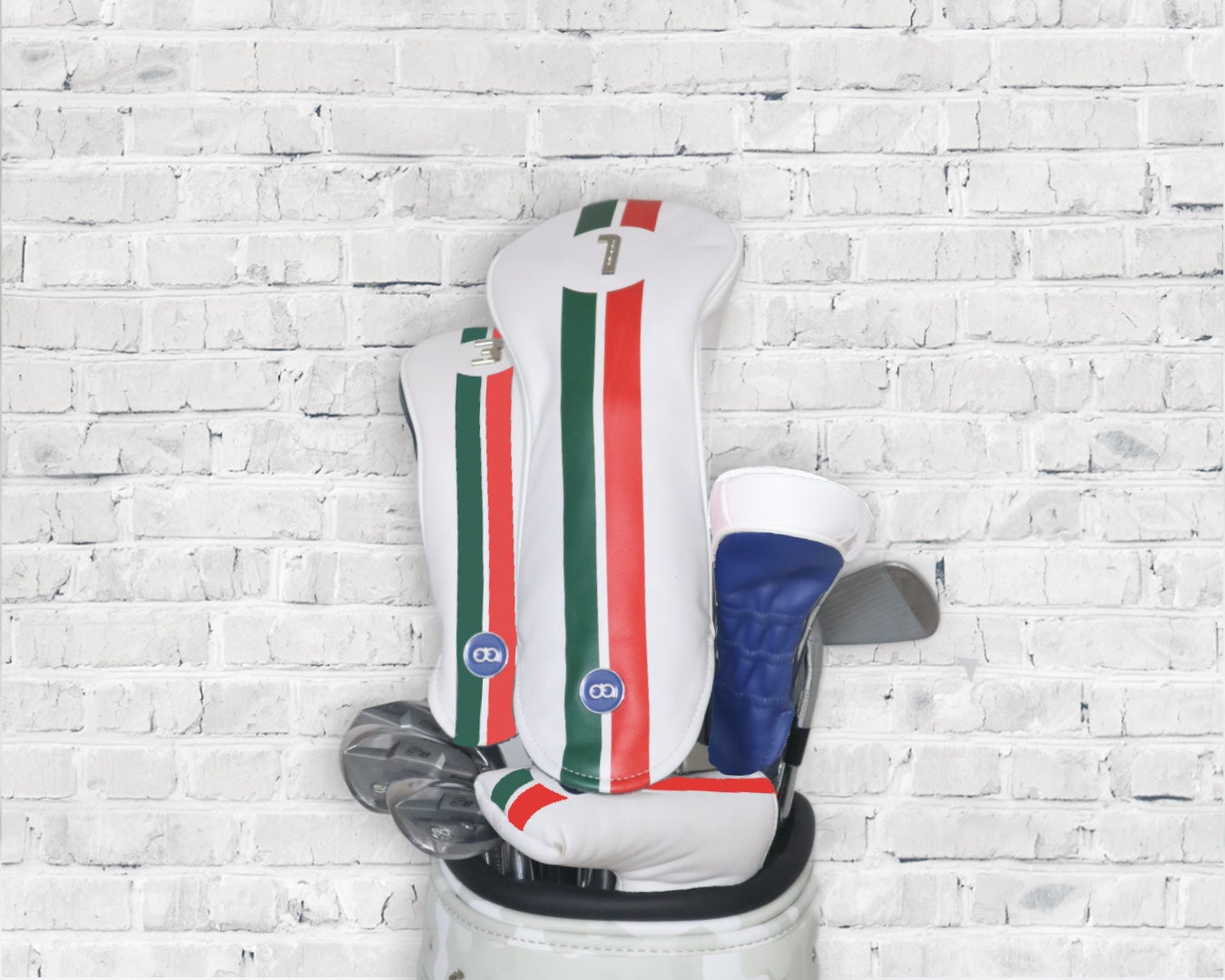 White and blue Italia leather golf club headcover set by David Alexander against a white wall background.