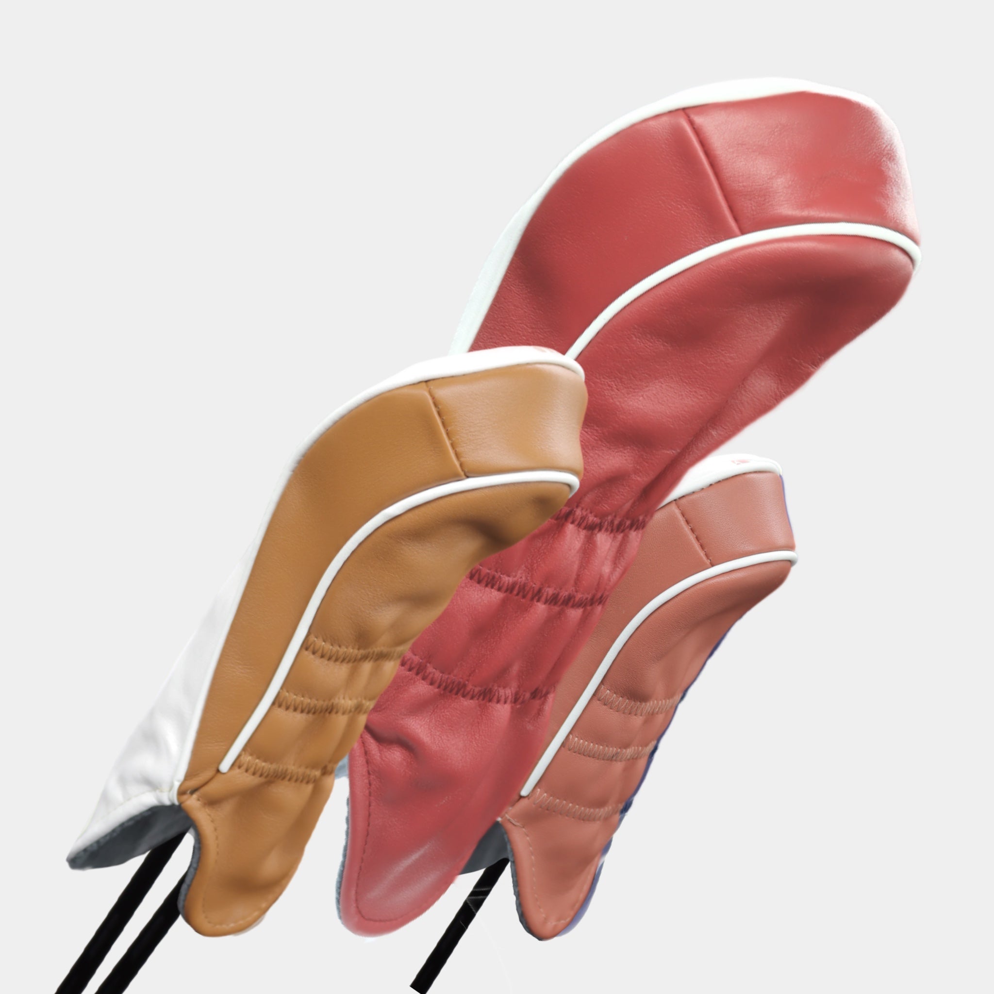 A set of scarlet, bronze and white leather golf club headcovers with a rose stripe design by David Alexander