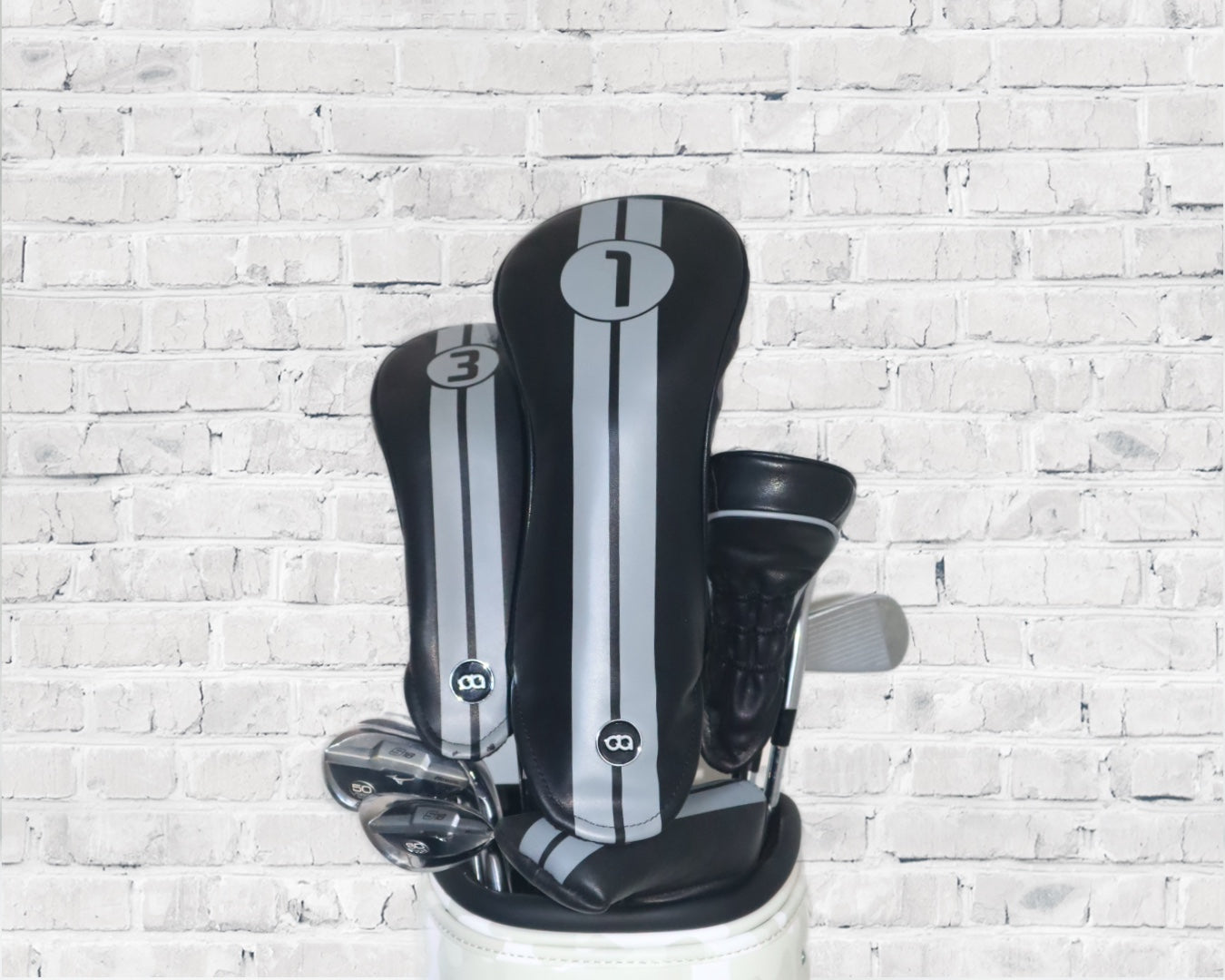 Black Racing Line leather golf club headcover set by David Alexander against a white wall background.