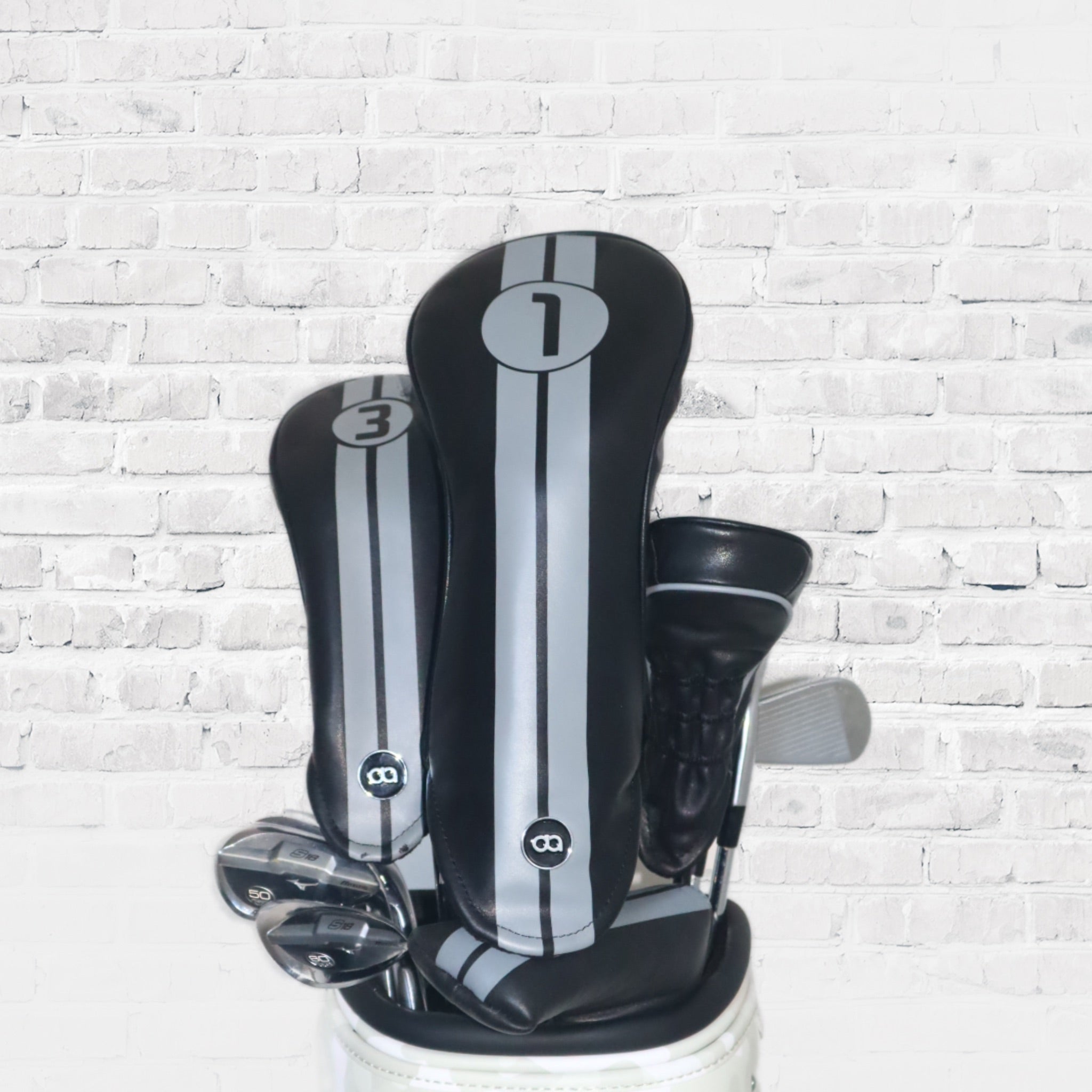 A set of black leather golf club headcovers with racing stripes by David Alexander