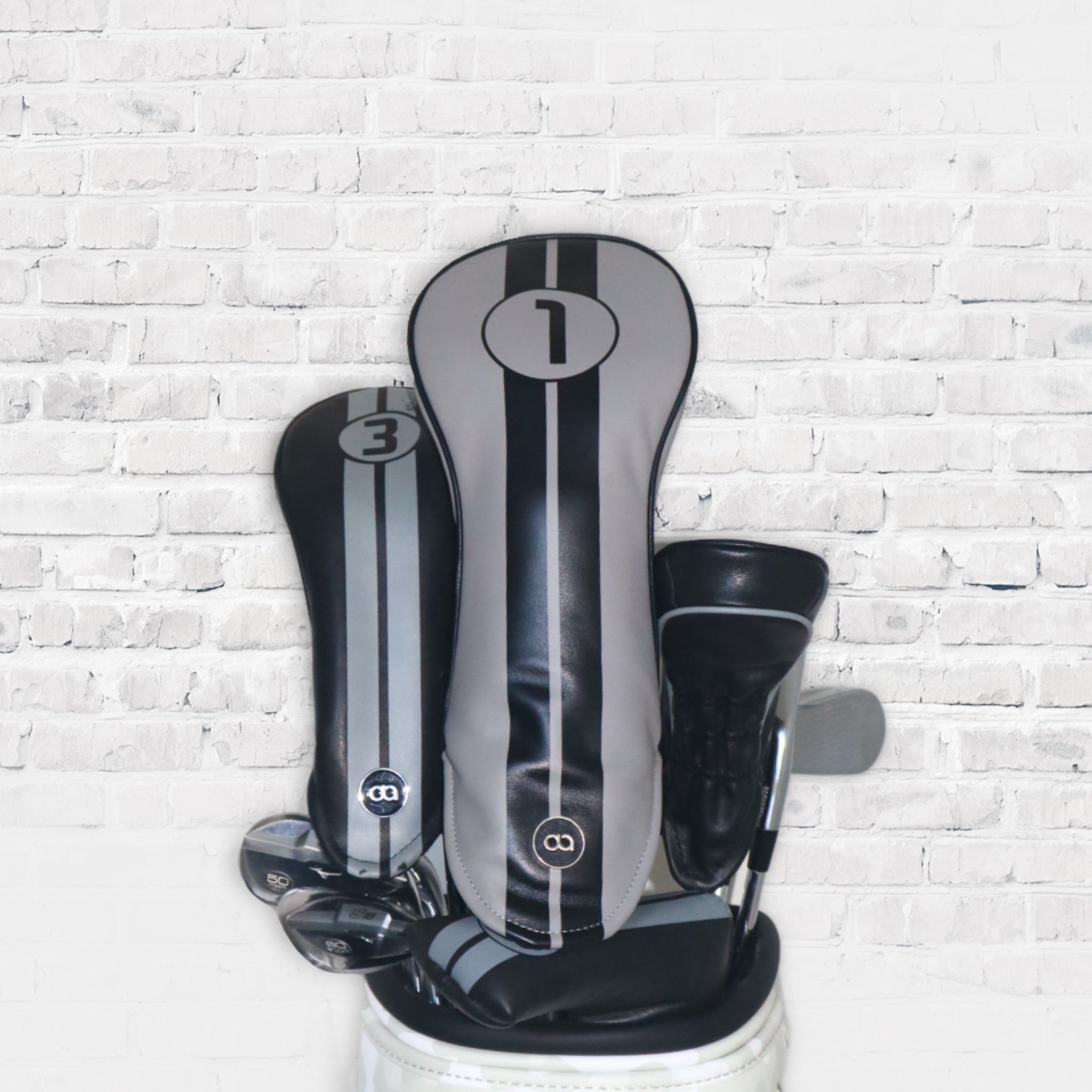 A set of grey and black leather golf club headcovers with racing stripes by Dave Alexander
