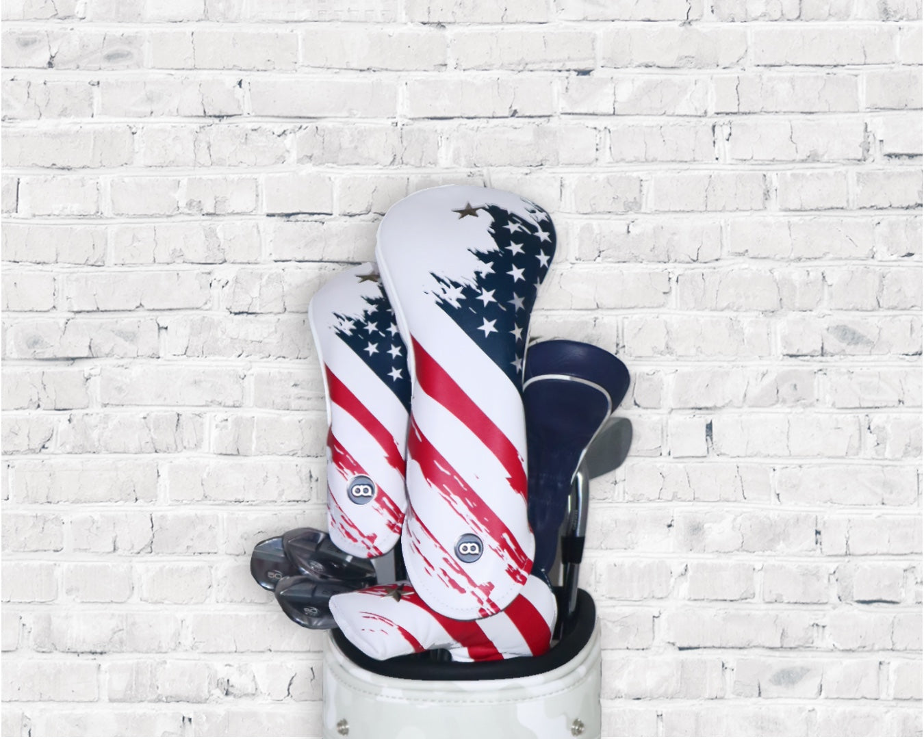 Red, white and blue USA leather golf club headcover set by David Alexander against a white wall background.