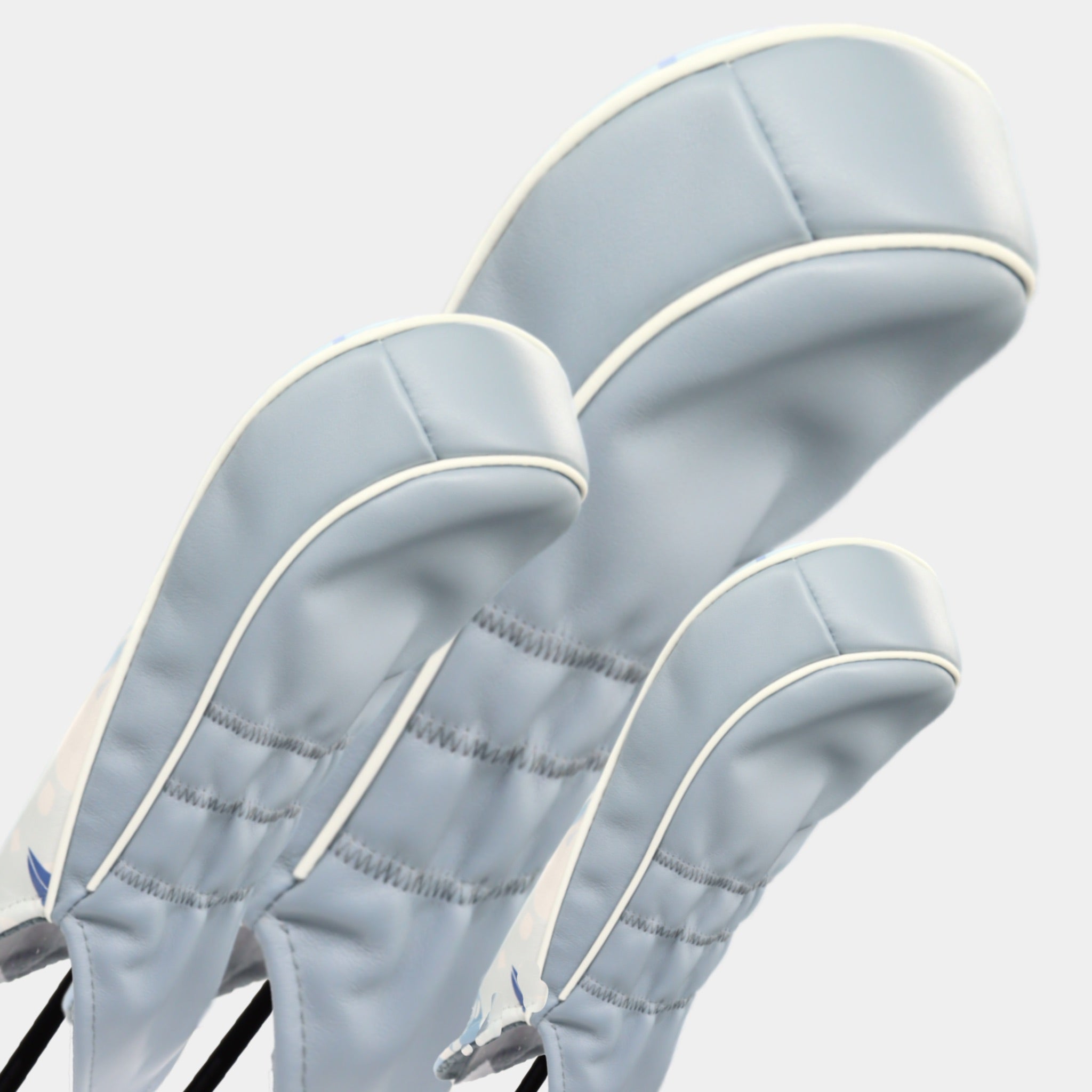 A set of grey and white leather golf club headcovers by Dave Alexander