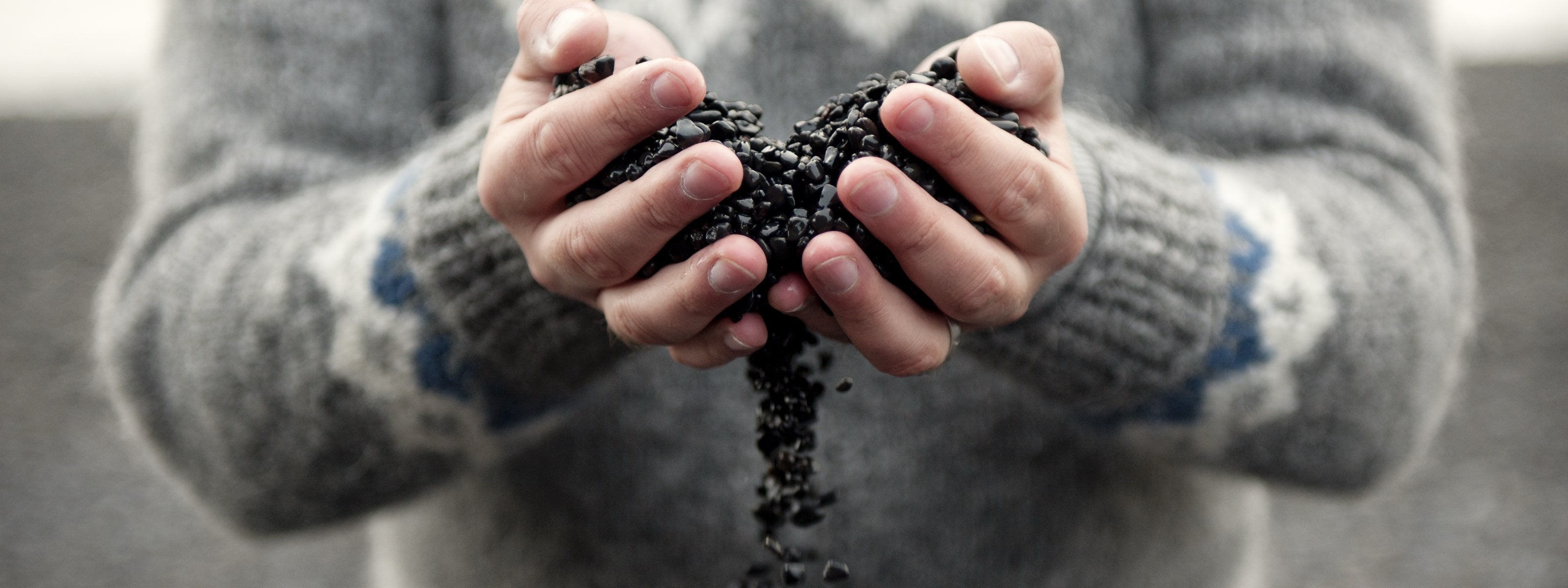 Man holding soil in their hands with a blurred background