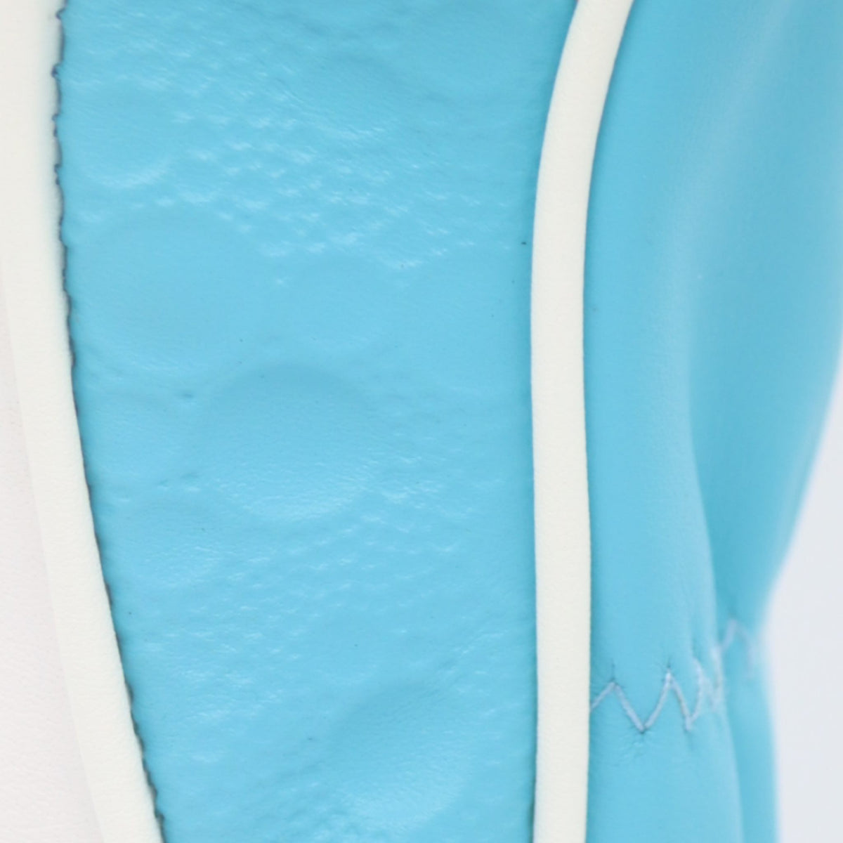Close-up of a moon emboss on the side of an aqua blue leather headcover by David Alexander l