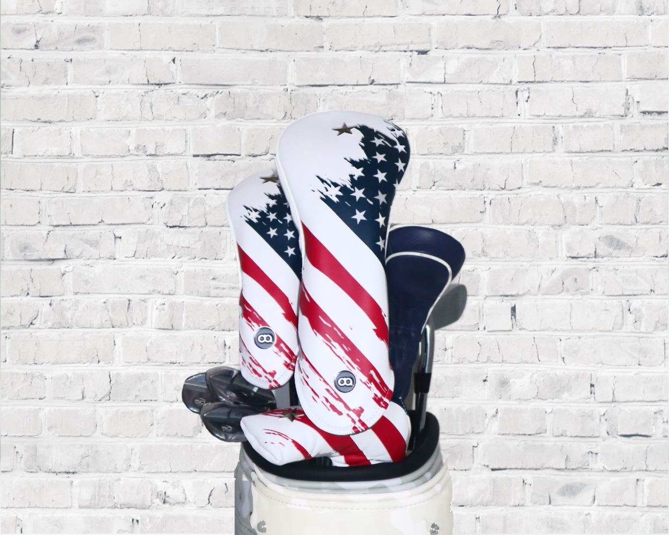 Red, white and blue USA leather golf club headcover set by David Alexander against a white wall background.